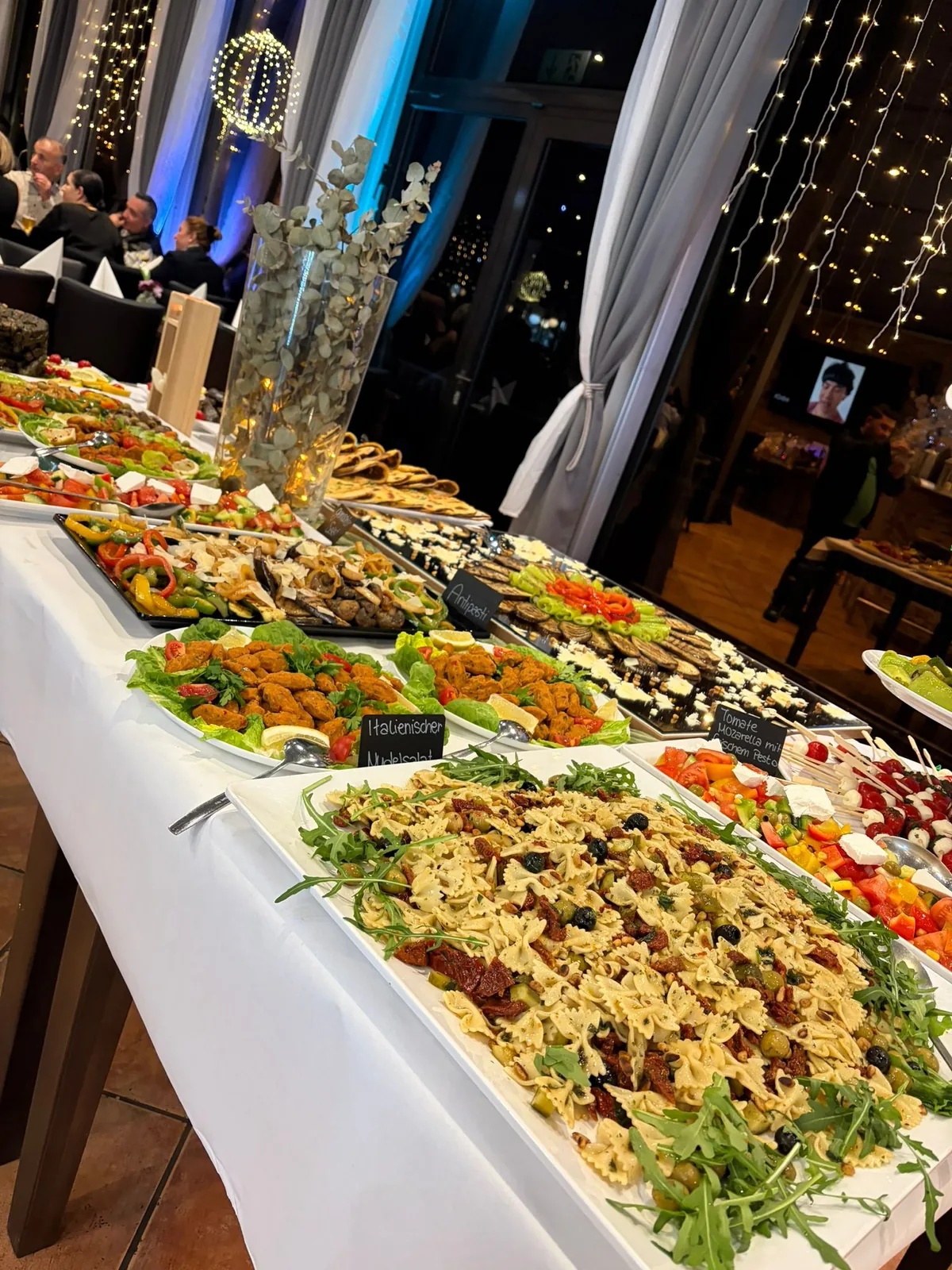 Lange Buffetstrecke mit Nudelsalat und Antipasti bei einer Abendveranstaltung