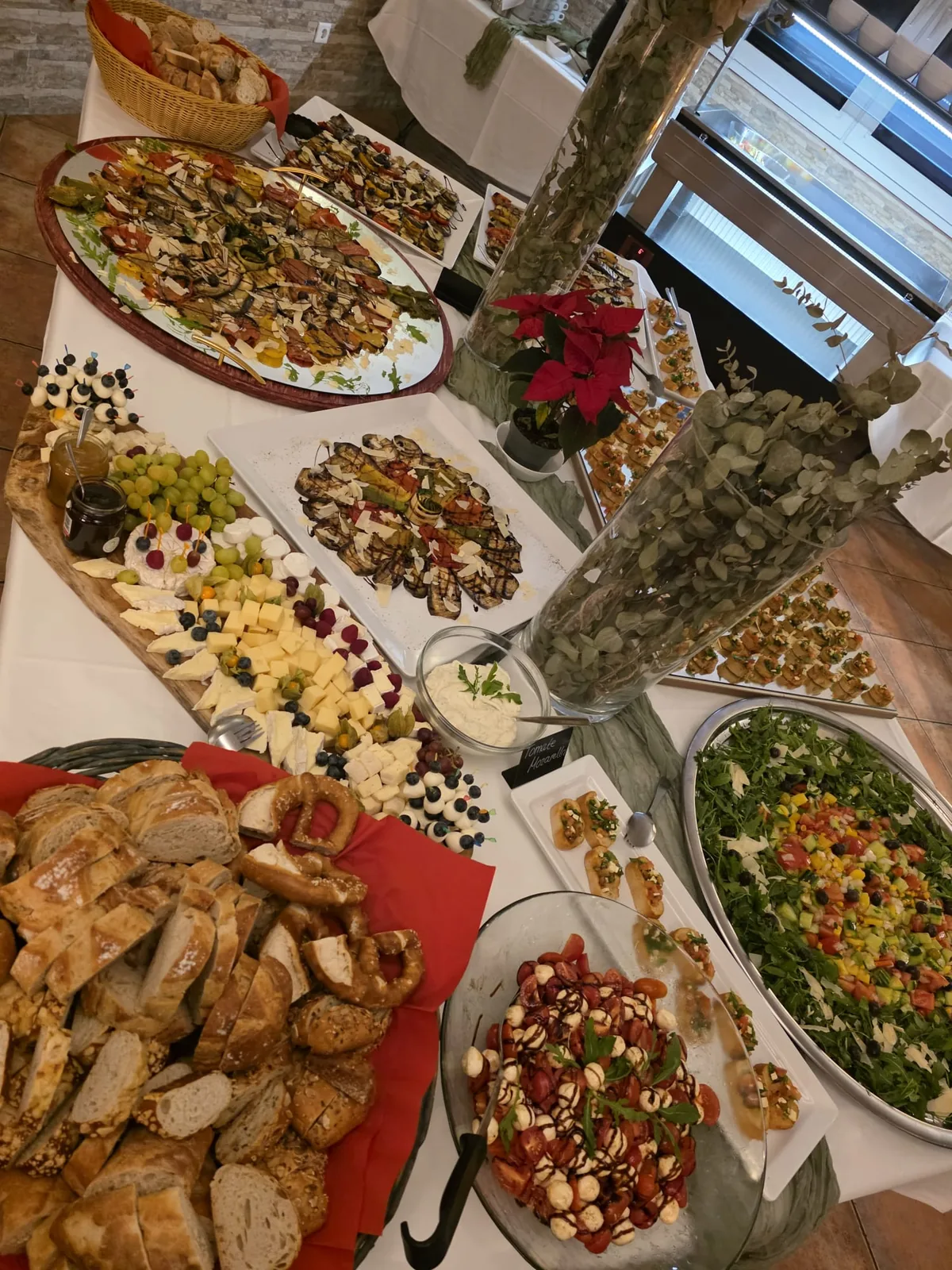 Käseplatte mit Trauben und Beeren, Brot, Brezeln und Grillgemüse von oben