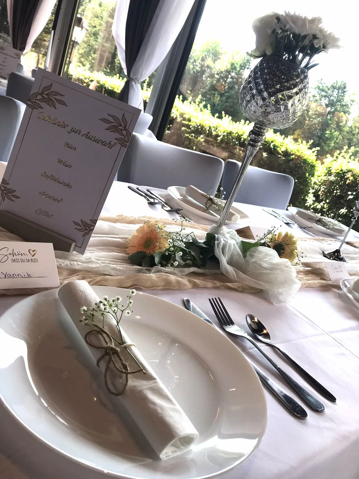 Gedeck mit gerollter Serviette, Schleierkraut und Platzkarte