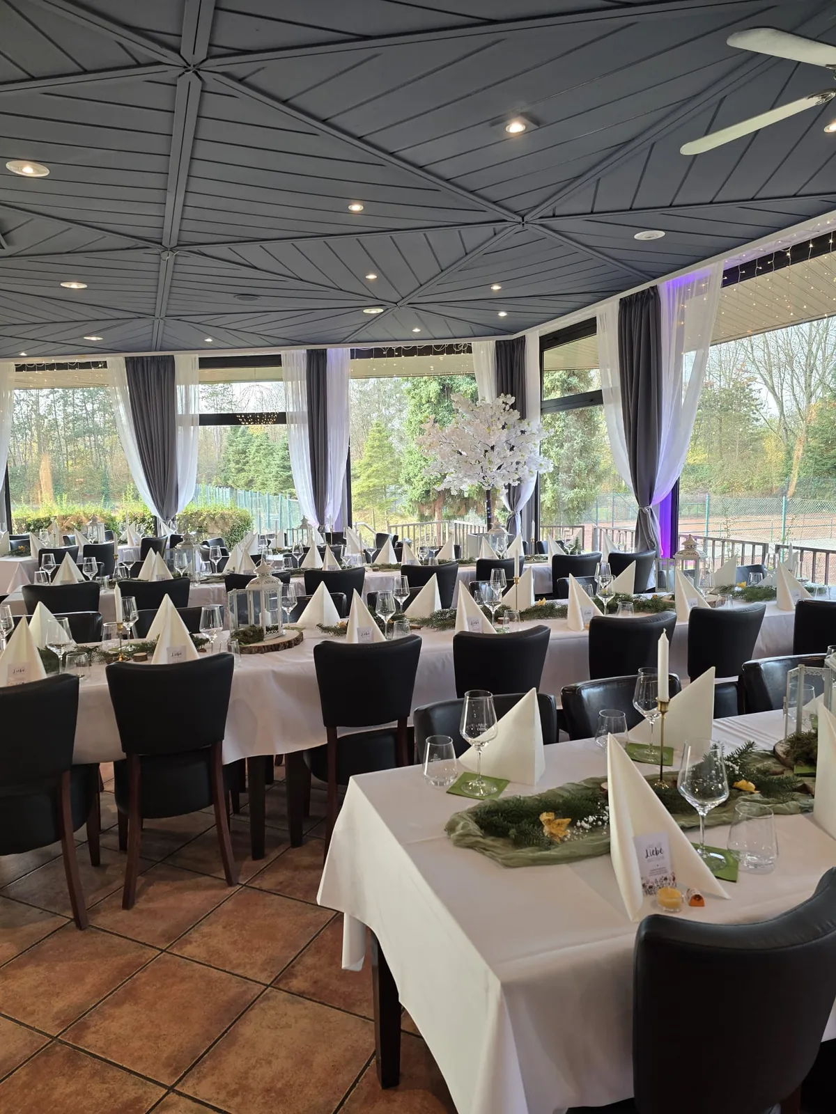 Saal-Überblick mit Panoramafenstern und eingedeckten Tafeln