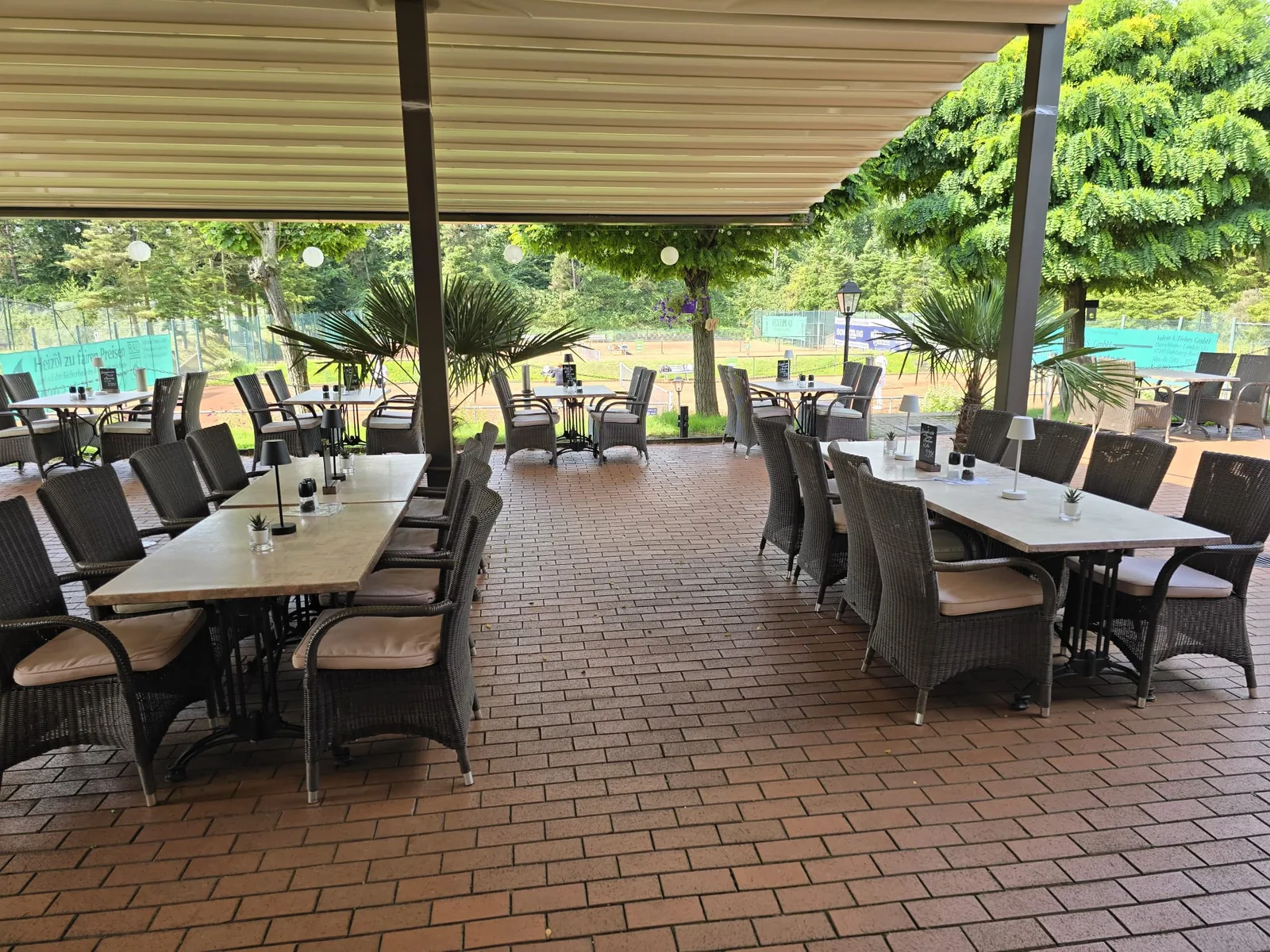 Terrasse mit Palmen, Steintischen und Lampions